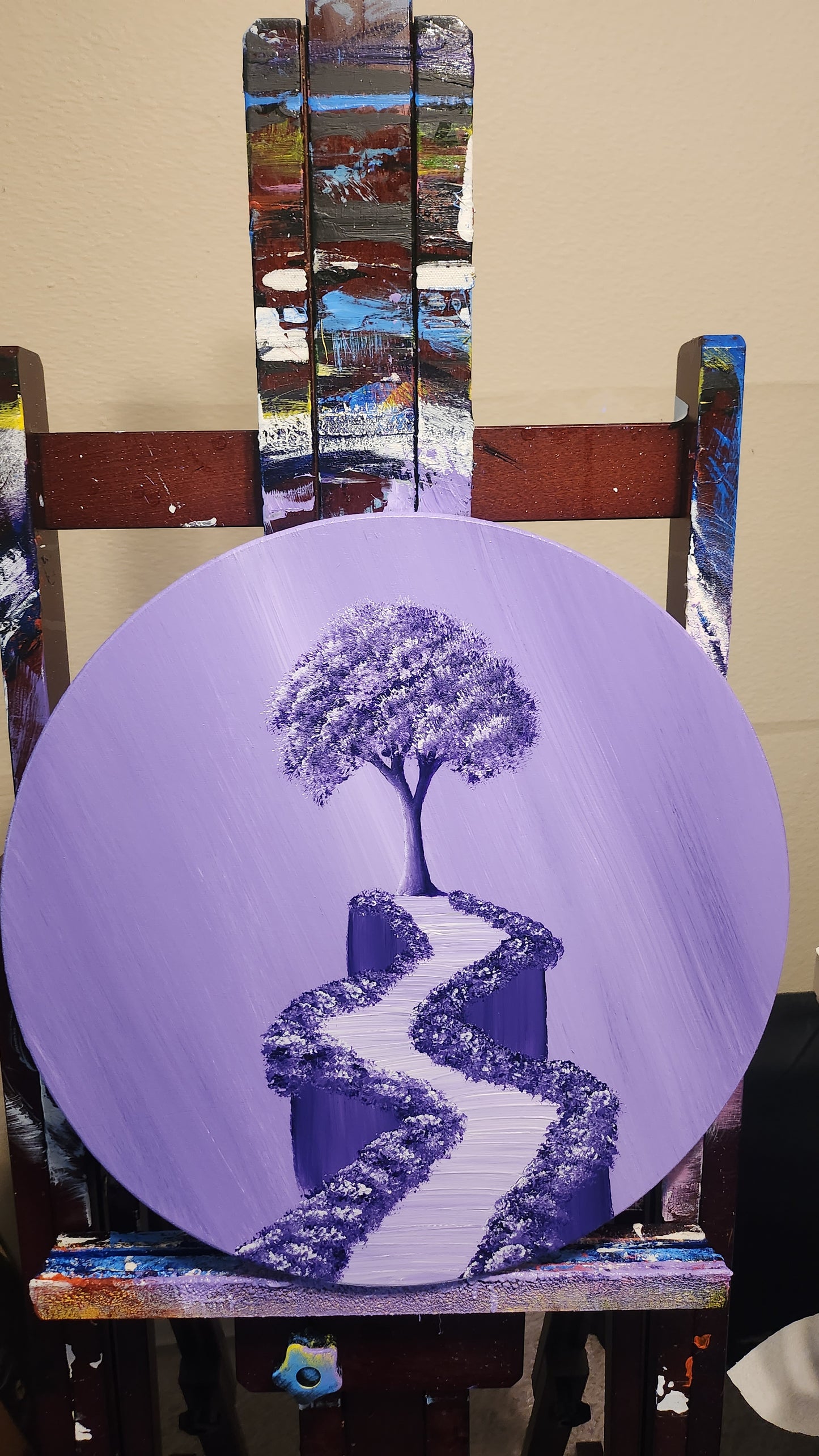 Lavender Dreams Original Painting: Painting on a wood circle panel on an easel of a purple sky and a purple tree and path