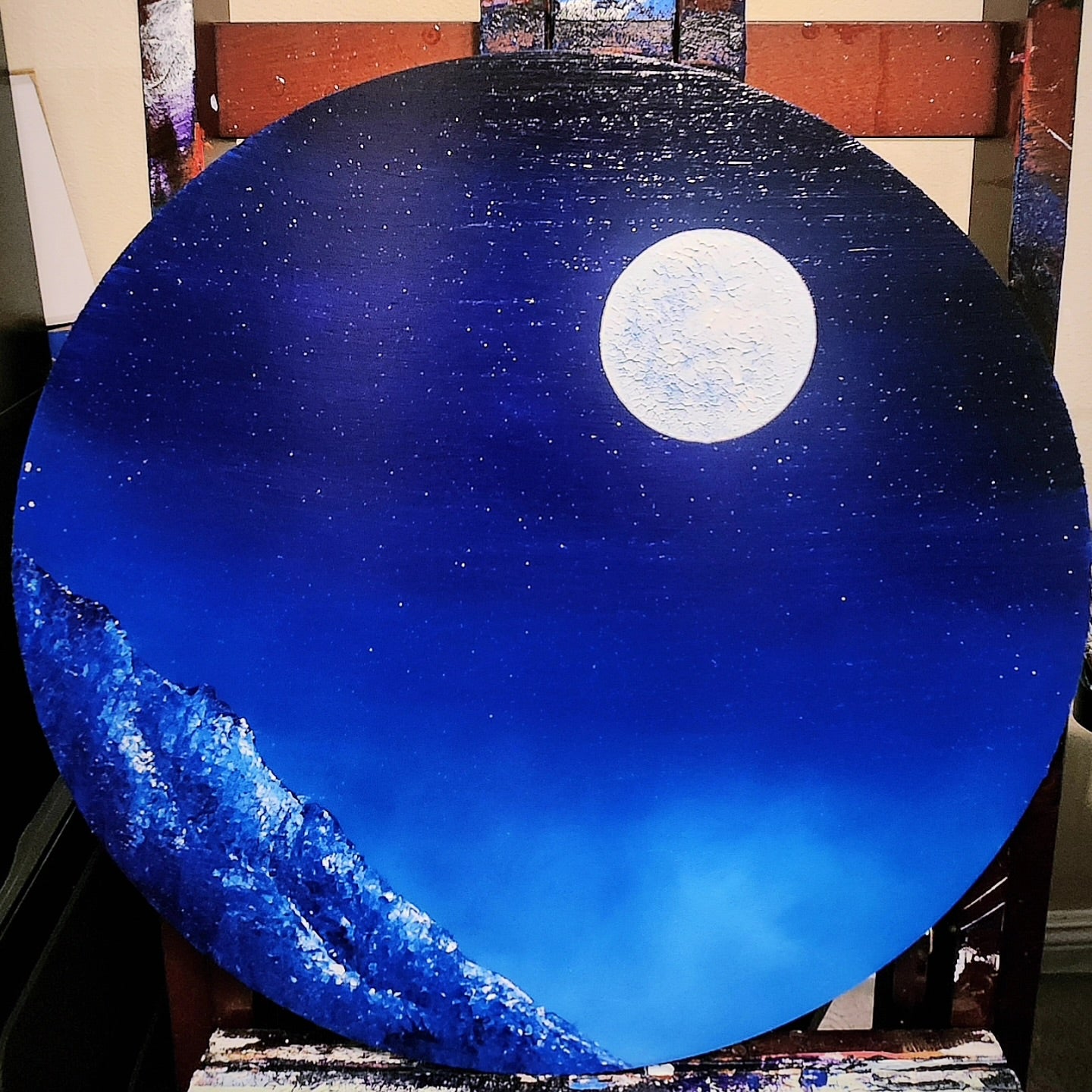 Mist Rise Original Painting: Circular artwork of a night sky with a full moon and mountains.