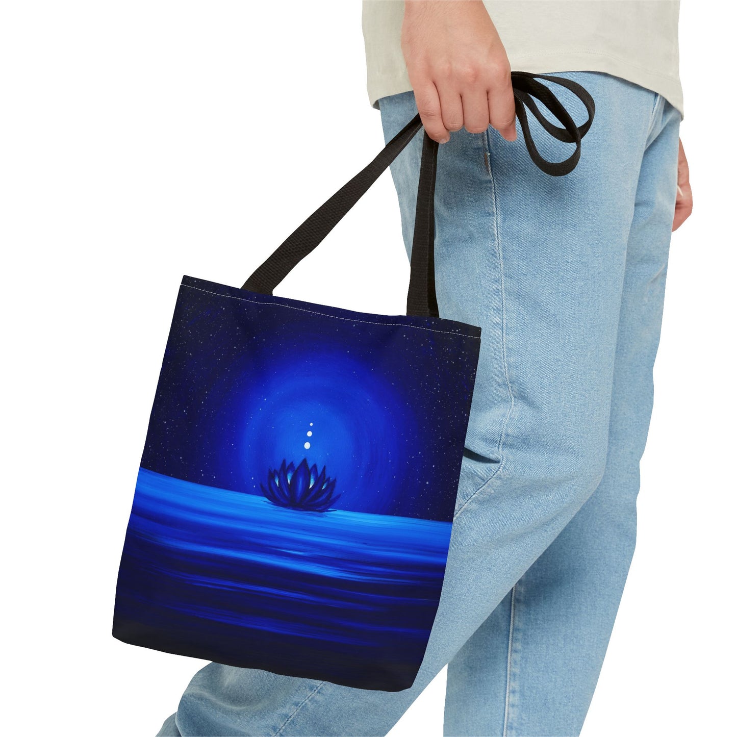 Tote bag with a blue design of a lotus flower and water held by a person wearing jeans.