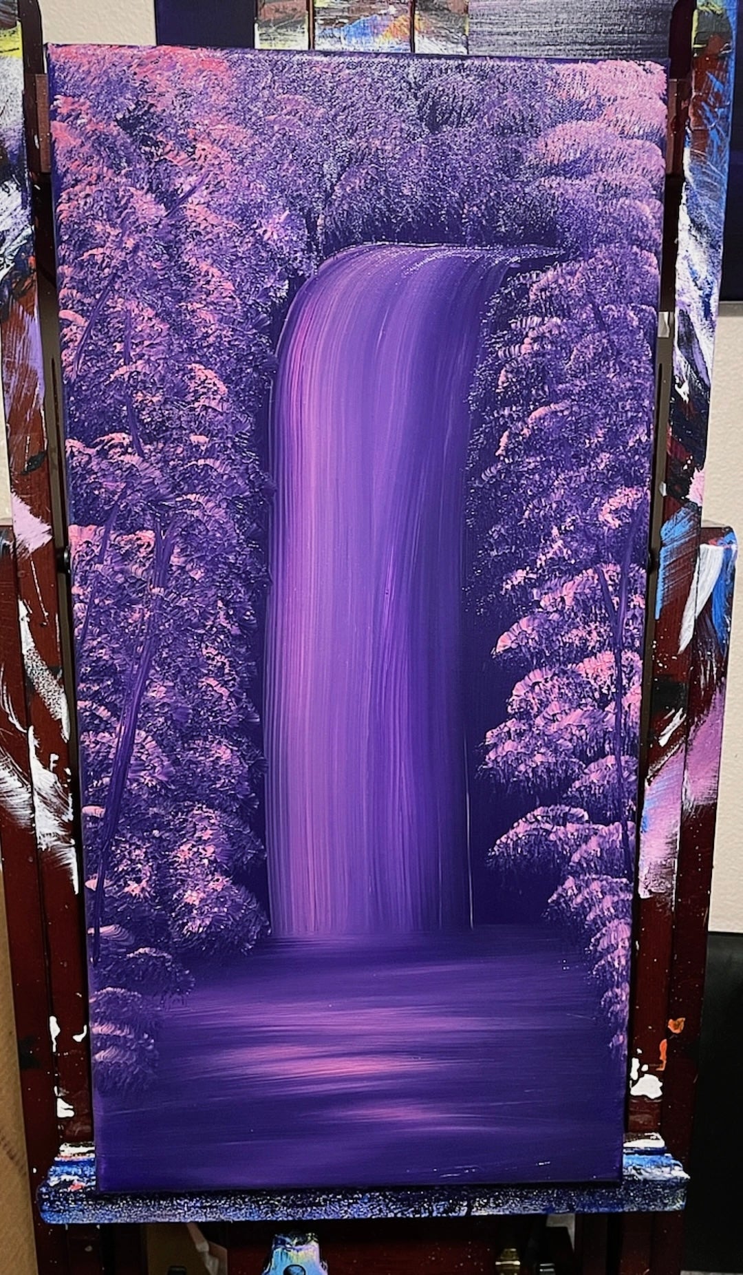 Purple waterfall painting against a purple forest background