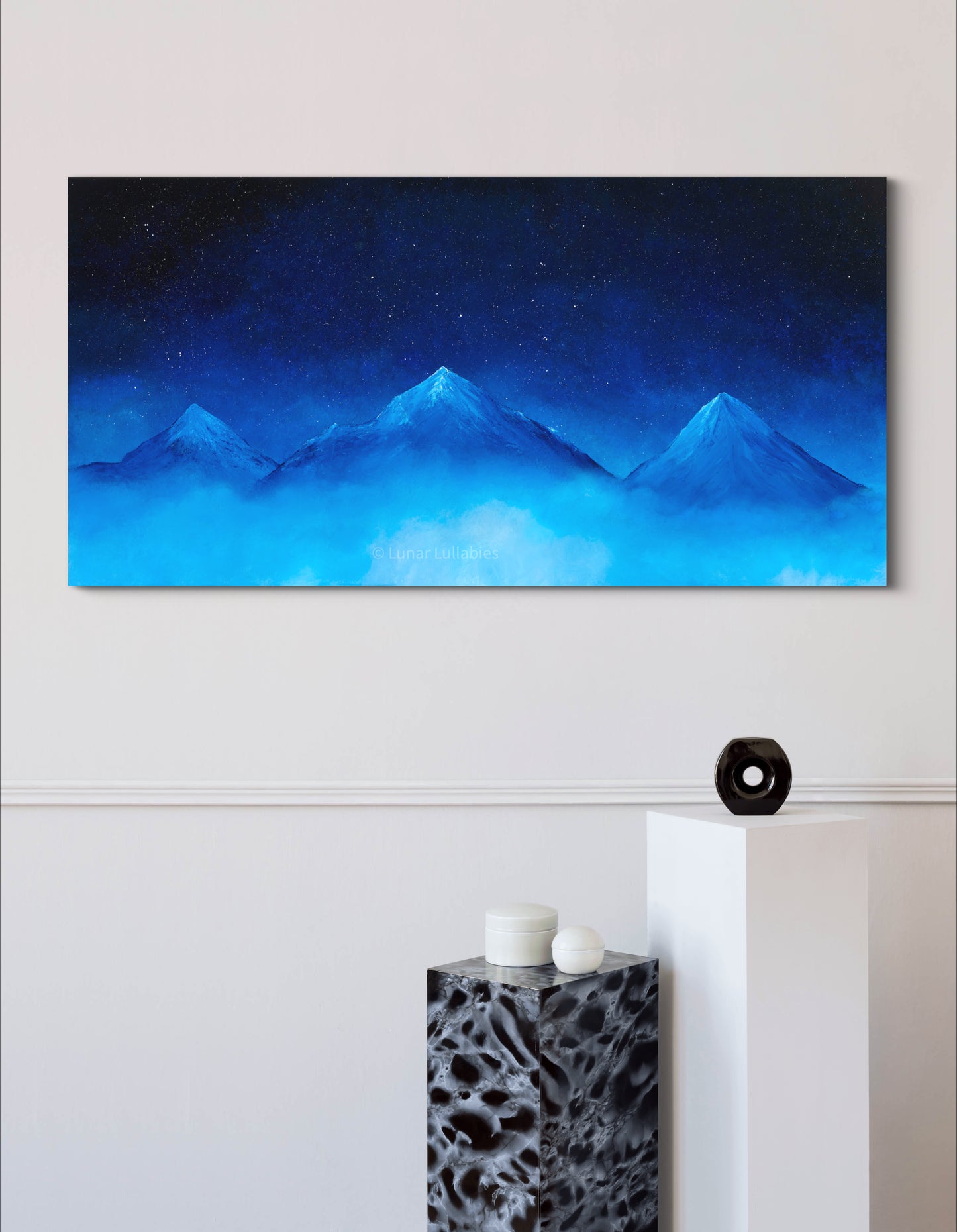 Mockup: Blue mountain landscape painting on a white wall with decorative elements below.