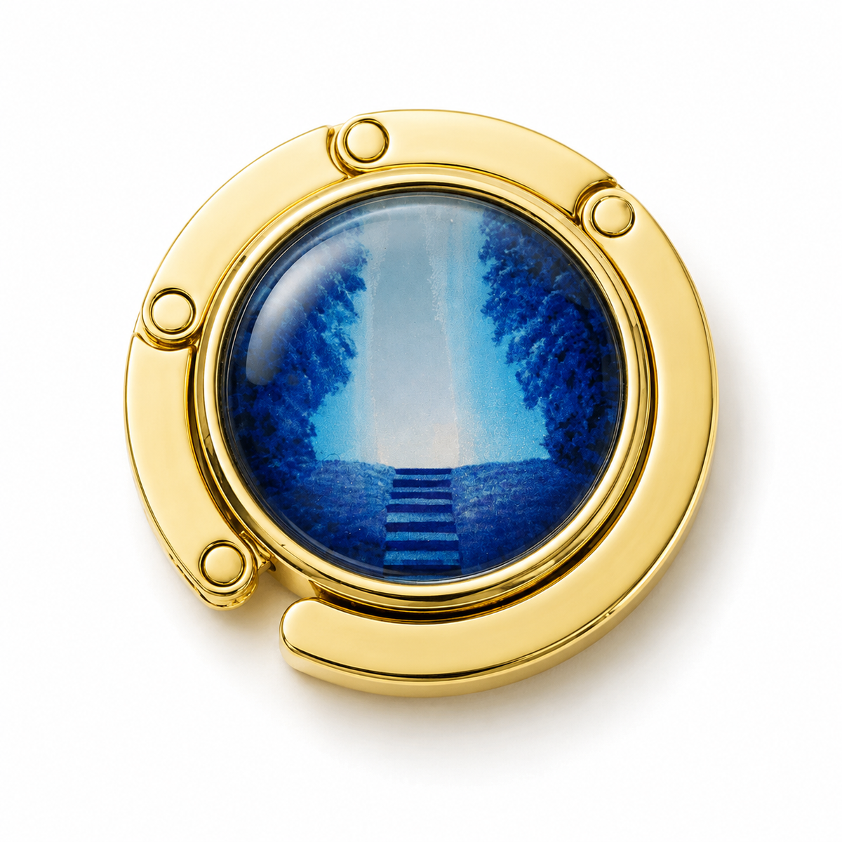 A gold-toned circular bag hook featuring a blue-toned scenic image of steps leading through trees, shown on a clean white background.