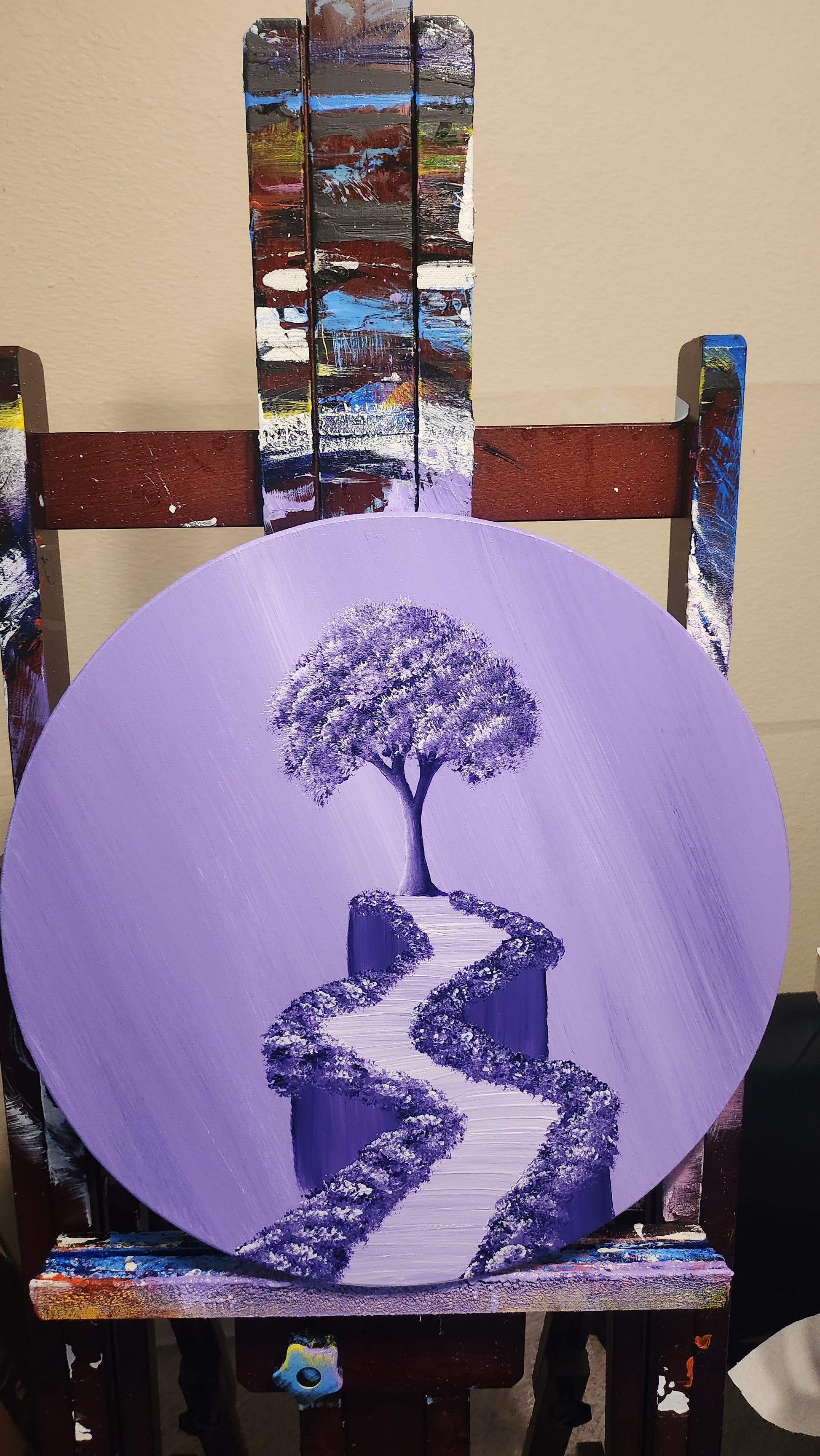 Lavender Dreams Original Painting: Painting on a wood circle panel on an easel of a purple sky and a purple tree and path