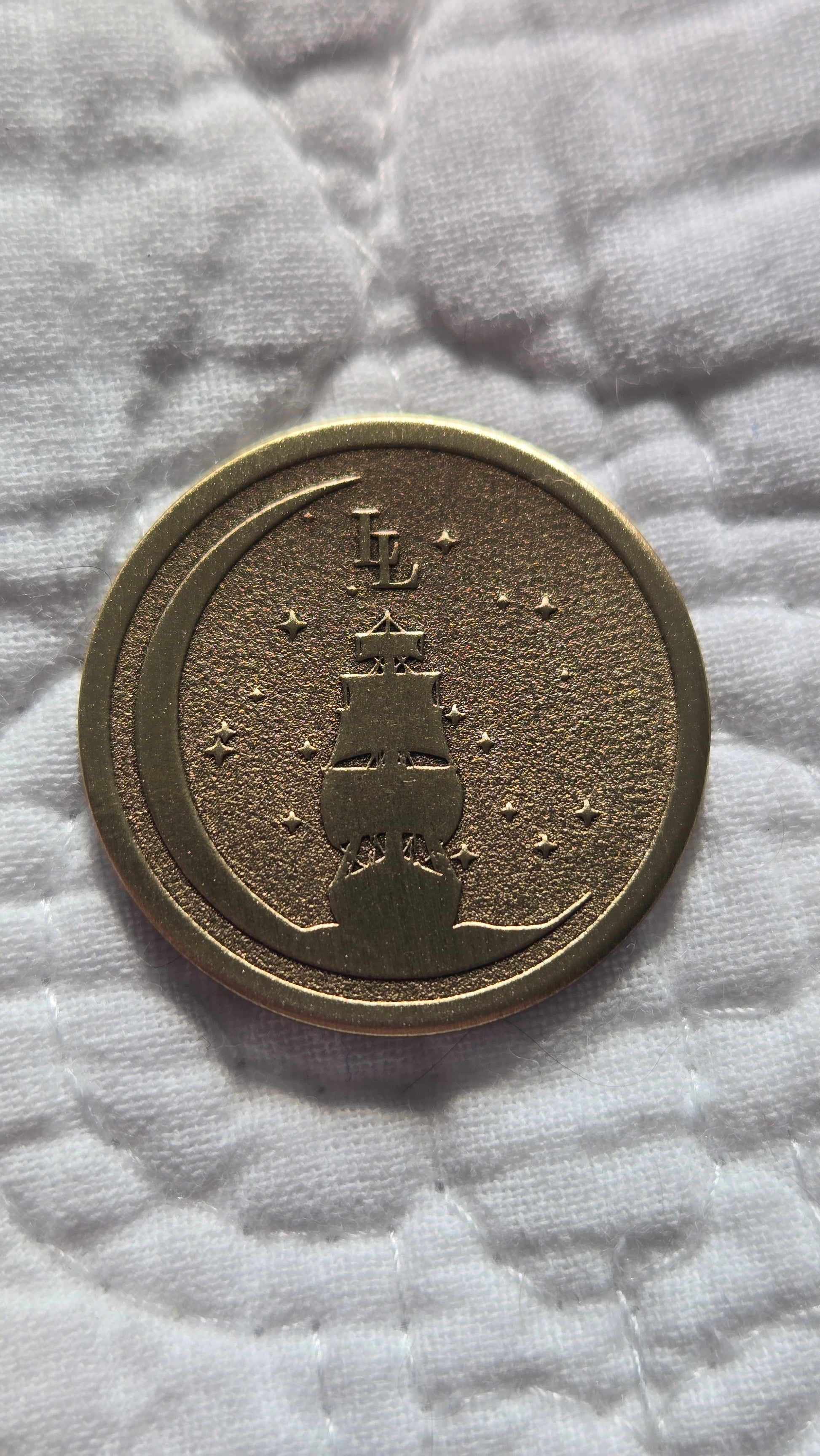 Bronze coin with embossed design on a textured white surface