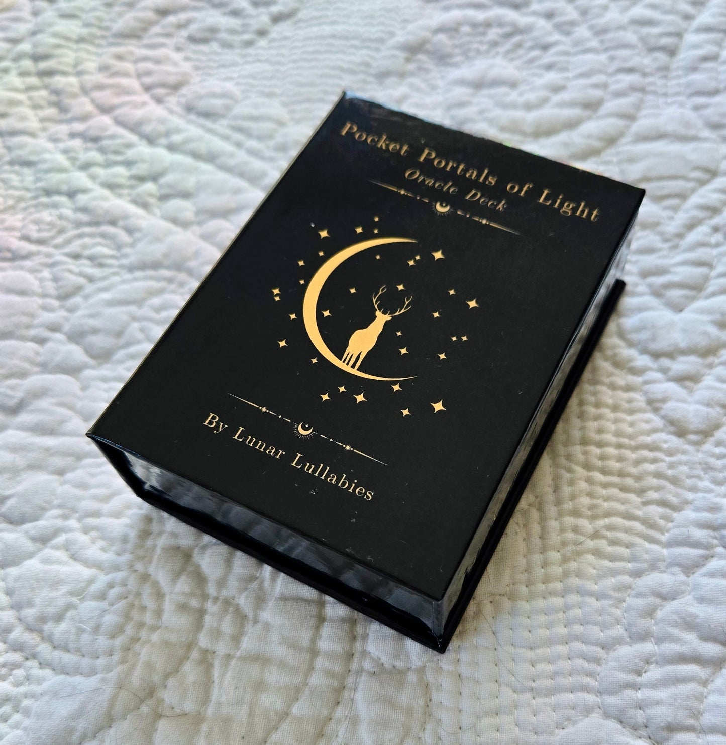 Black Oracle Deck packaging with gold design on a textured white surface