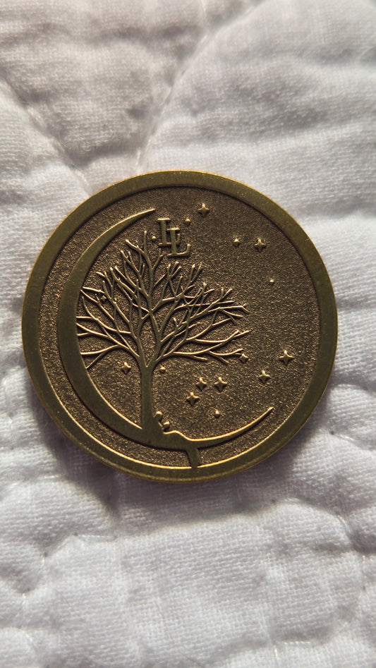 Bronze coin with tree design on a white fabric background