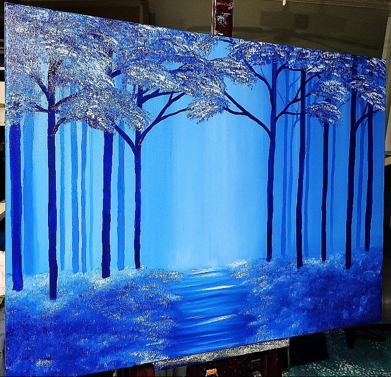 Blue forest painting on an easel of trees and a path 