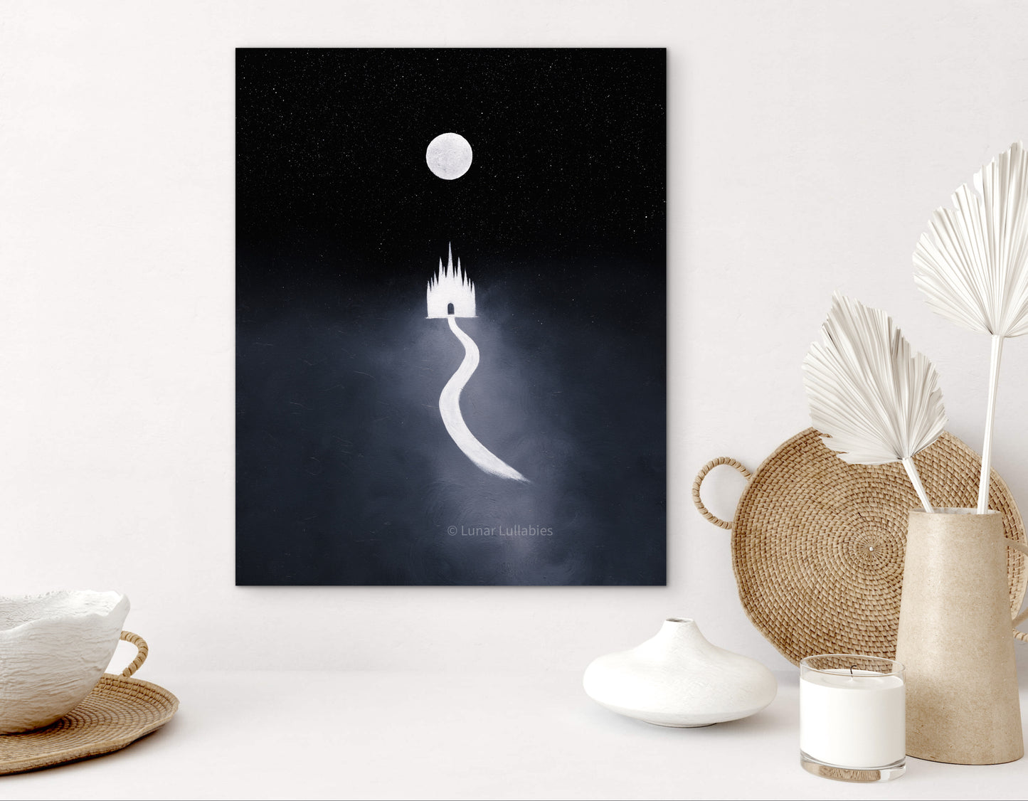 Mockup: Artwork of a castle silhouette against a dark background on a white surface with decorative items.