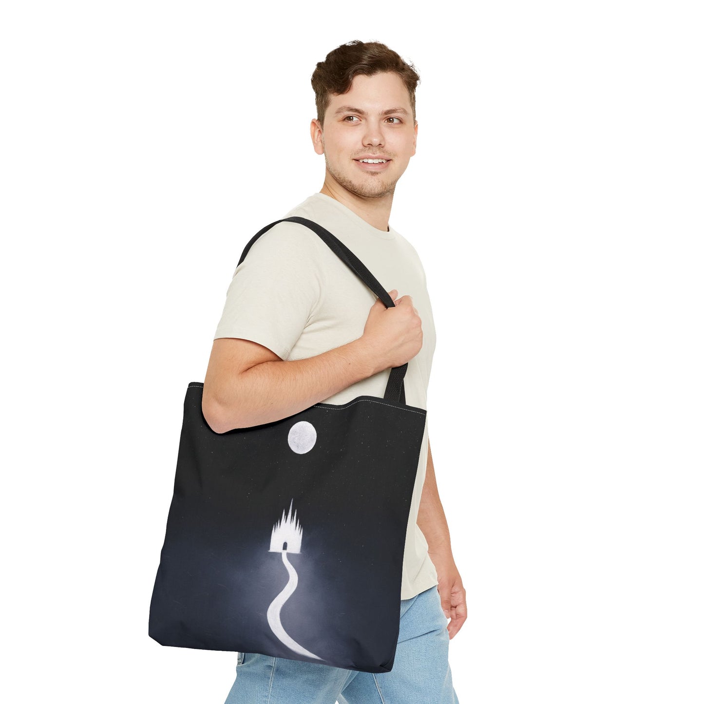 Man holding a black tote bag with a white design on a white background