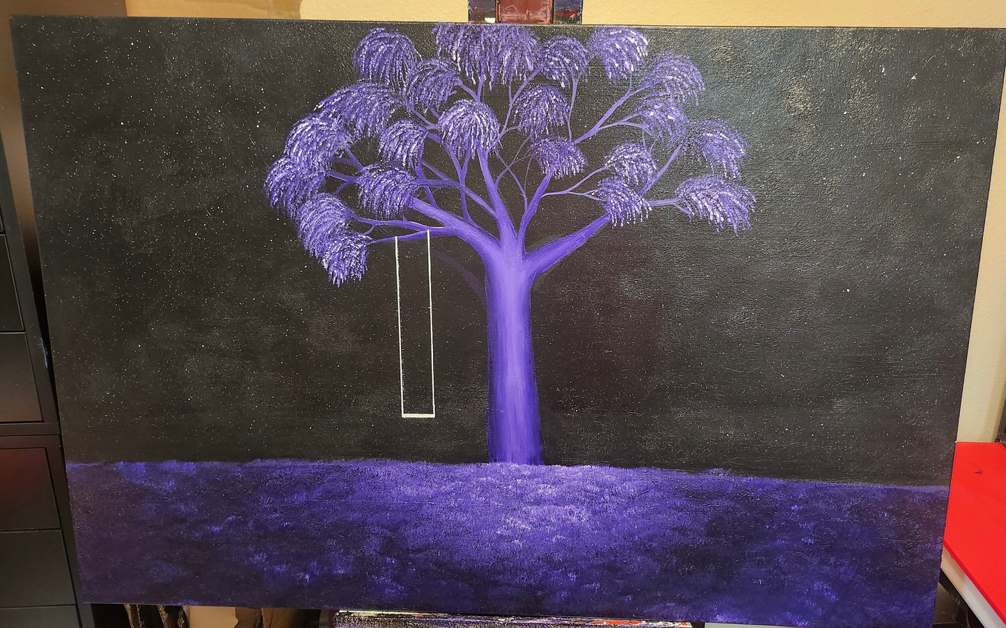 A painting on an easel of a purple tree and a white swing